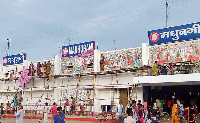 people painting the walls of Madhubani Junction